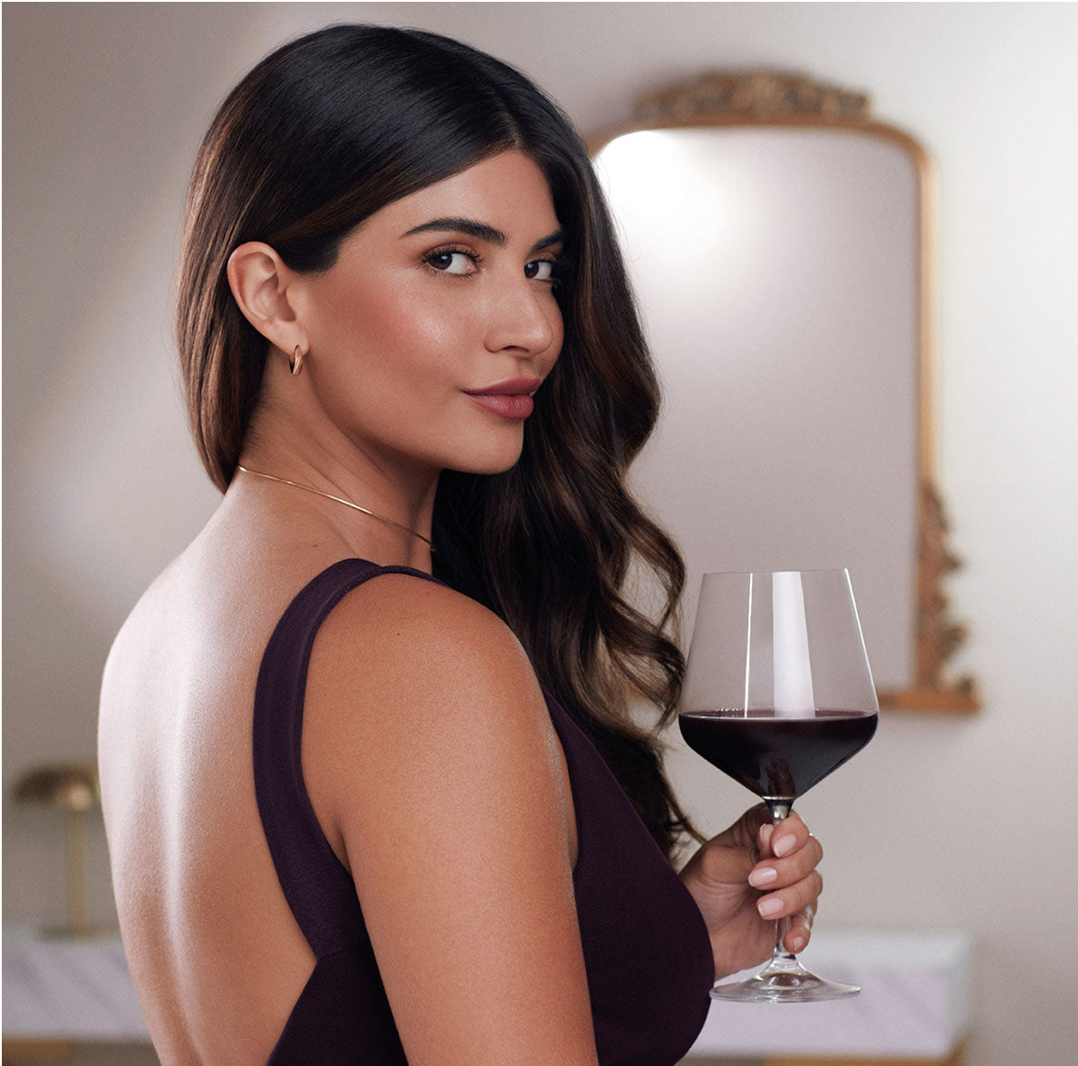 Woman holding a glass of red wine indoors
